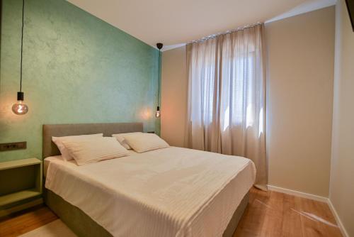 a bedroom with a large bed with a window at Noir Design Wohnung in Trogir