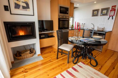 eine Küche mit Tisch und Kamin in einem Zimmer in der Unterkunft Ferienhaus für 2 Personen ca 50 qm in Algarvia, Azoren Sao Miguel in Algarvia
