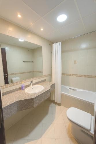 a bathroom with a sink and a toilet and a mirror at TravelTime Marina in Dubai