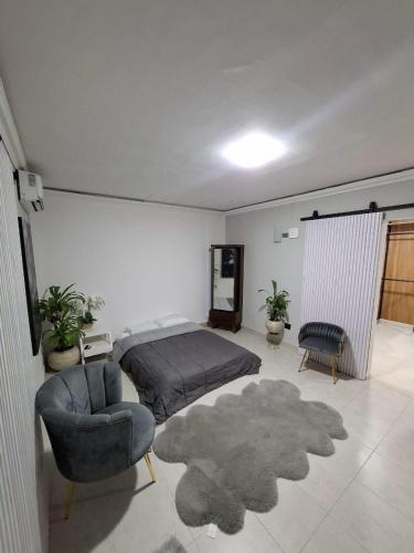 a bedroom with a bed and a chair and a rug at suites vergel planta alta in Orizaba