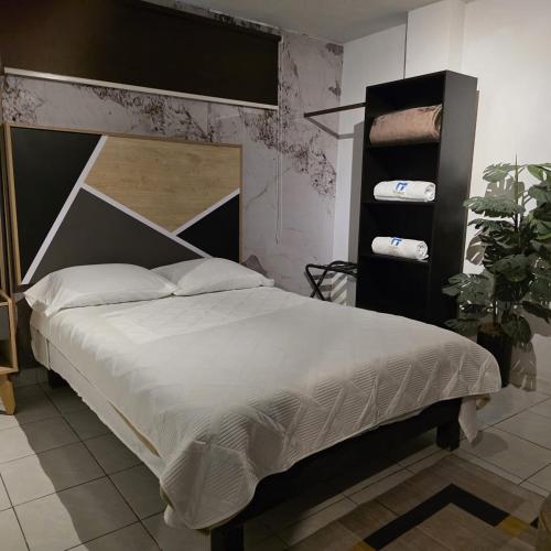 a bedroom with a large bed with a black headboard at El Hostalito Metepec in Toluca