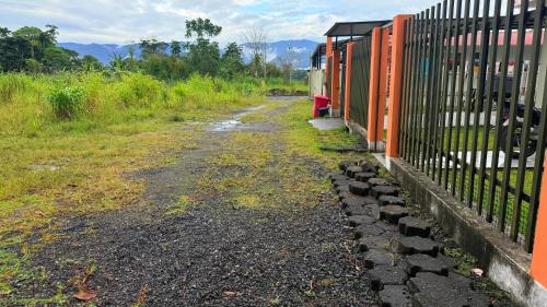a fence next to a dirt road next to a fence at Habitación doble # 3 in Macas