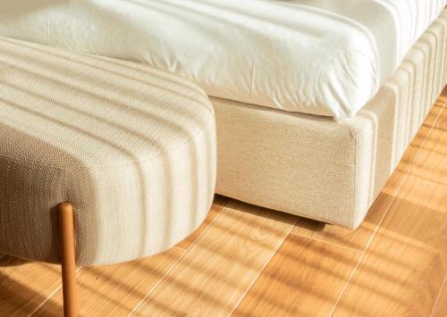 eine Couch und ein Hocker neben einem Bett in der Unterkunft Tenuta Tommasi - Relais Bacco in Caorle