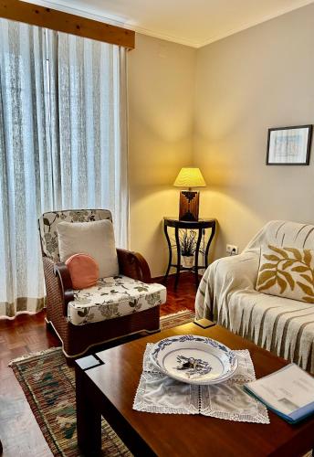 a living room with a chair and a table at Casa da Avó - Vila do Porto in Vila do Porto