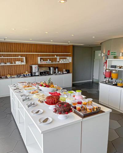 uma linha de buffet com comida na cozinha em Samba Bossa Nova Cabo Frio em Cabo Frio