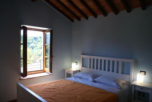 - une chambre avec un lit, une fenêtre et 2 lampes dans l'établissement Sunset Barga Toskana Kürzlich Renoviert, à Barga