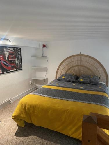 une chambre avec un lit avec une couverture jaune dans l'établissement Appartement Hyper Centre, à Limoges