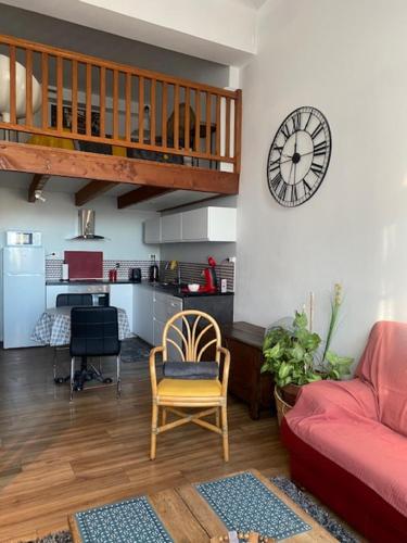 ein Wohnzimmer mit einem Sofa und einer Uhr an der Wand in der Unterkunft Appartement Hyper Centre in Limoges