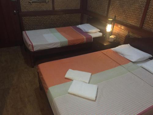 a hotel room with two beds with white pillows at Pagdayon Traveler's Inn in Puerto Princesa City