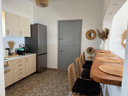 eine Küche mit Tisch und Stühlen und einem Kühlschrank in der Unterkunft AMBELI Luxury Apartment in Schinoussa