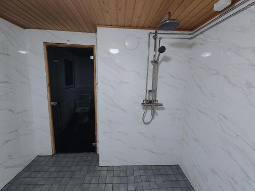 une douche dans une chambre avec une porte noire dans l'établissement Arctic Aurora Villa with a Lappish Grill Hut - Northern Lights and Private Sledding Hill in the Backyard, in the Hometown of Santa Claus, Rovaniemi, à Rovaniemi