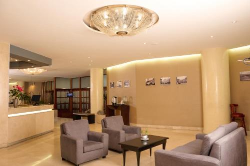 a waiting room with chairs and a chandelier at Hotel Dann Av. 19 in Bogotá