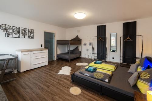 een woonkamer met een bed en een bureau bij Homefeld Suite - Elegante und moderne Ferienwohnung zentral in Hünfeld bei Fulda mit Küche, kostenlosem Parkplatz und WLAN in Hünfeld