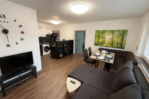 een woonkamer met een bank en een tafel bij Homefeld Suite - Elegante und moderne Ferienwohnung zentral in Hünfeld bei Fulda mit Küche, kostenlosem Parkplatz und WLAN in Hünfeld