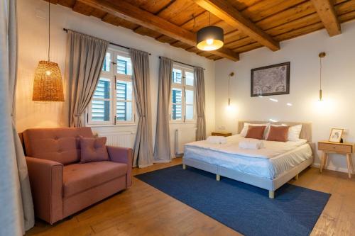 a bedroom with a bed and a chair at Gabri Guesthouse Transylvania in Aita Seacă