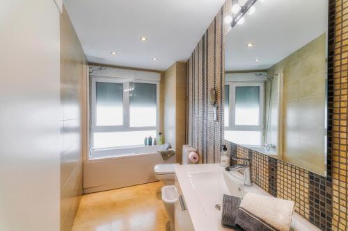 une salle de bain avec un lavabo et des toilettes et des fenêtres dans l'établissement centro / internet / parking / aire acondicionado, à Elche