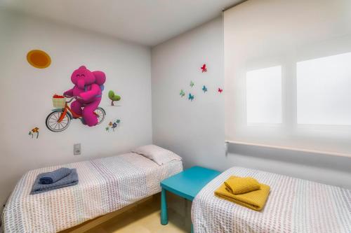 une chambre avec deux lits et un ours en peluche sur un vélo dans l'établissement centro / internet / parking / aire acondicionado, à Elche