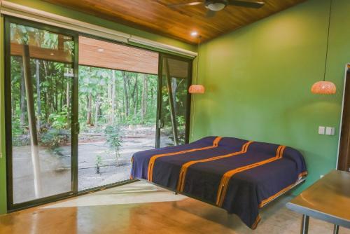 - une chambre avec des murs verts et une grande fenêtre dans l'établissement Avellanas Private Villa, à Santa Cruz