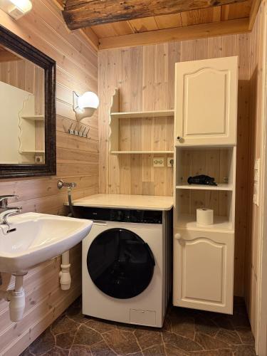 a bathroom with a sink and a washing machine at Rugsund Handelsstad in Rugsund