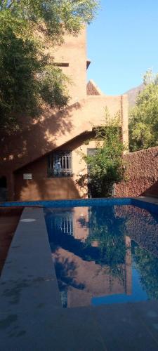 a reflection of a building in a swimming pool at la maison mondiale ouirgane in Ouirgane