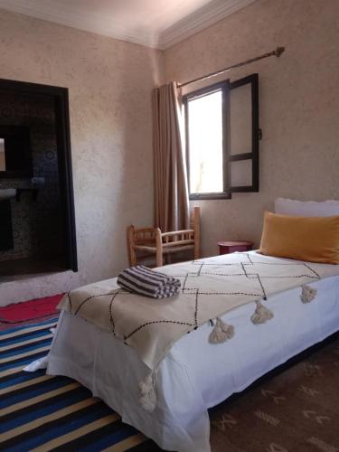 a bedroom with a large bed and a window at la maison mondiale ouirgane in Ouirgane