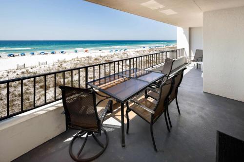 un tavolo e sedie su un balcone con vista sulla spiaggia di Surf Dweller 309 Large gulf front condo a Fort Walton Beach