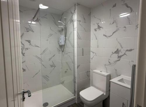 a bathroom with a shower and a toilet and a sink at Sarah's Woodland Golf Stays in Waterloo