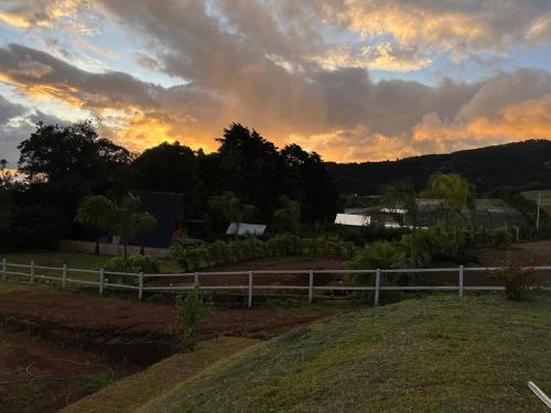 a fence in a field with a sunset in the background at Green haven Poas in Poasito