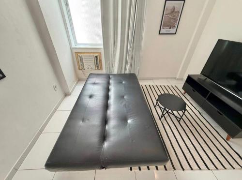 een zwarte bank in een kamer met een televisie bij Centro - Divino apartamento in Rio de Janeiro