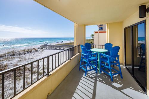 a balcony with blue chairs and a table and the beach at Surf Dweller 312 Large gulf front in Fort Walton Beach