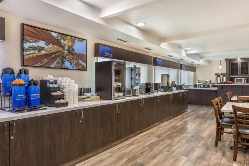 un restaurante con un bar con mesa y sillas en Best Western Town & Country Lodge, en Tulare