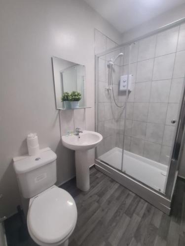 a bathroom with a toilet and a shower and a sink at Hotel 52 in Whitley Bay