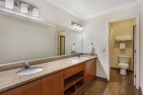 a bathroom with two sinks and a toilet at Best Western Town & Country Lodge in Tulare