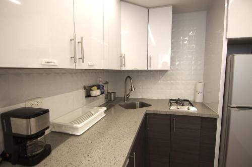 La Finca Sunset - Fajardo 1 Bed NEW في Playa de Fajardo: مطبخ بخزائن بيضاء ومغسلة