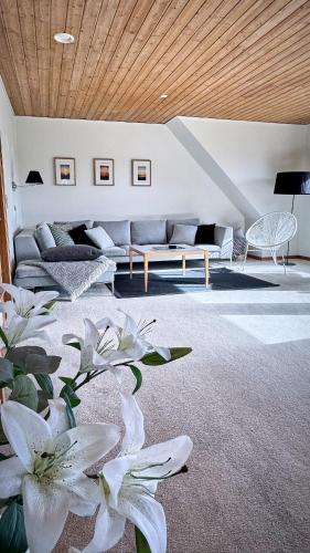 a living room with a couch and white flowers at Stylish vacation home - close to sea and nature in Hejls