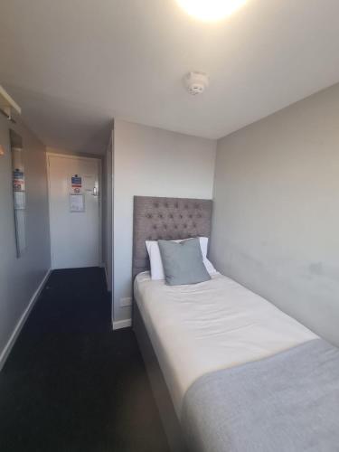 a bedroom with two beds and a light on the ceiling at Hotel 52 in Whitley Bay
