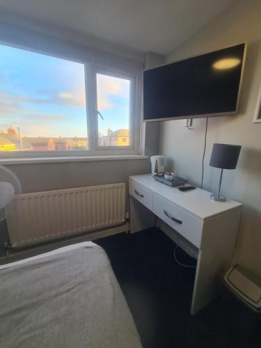 a hotel room with a bed and a desk and a window at Hotel 52 in Whitley Bay