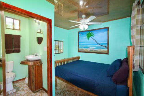 大玉米岛Hospedaje Rosa Del Mar & Sweets Cafe的一间卧室配有一张床、一个水槽和吊扇