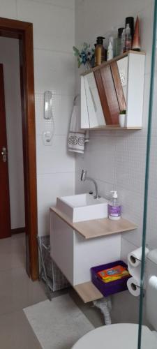 a bathroom with a white sink and a toilet at 57m2, quarto casal, colchonete extra, super arejado in São José