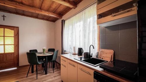 une cuisine avec une table, des chaises et un comptoir dans l'établissement Domek w Murzasichlu z kominkiem, à Murzasichle