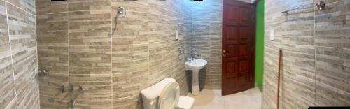 ein Badezimmer mit Dusche, Toilette und Waschbecken in der Unterkunft El kincho in Humahuaca