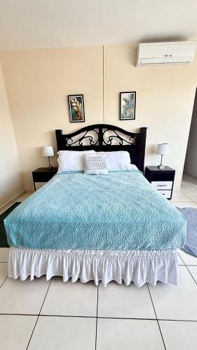 a bedroom with a large bed with a blue comforter at Moderno y cómodo apartamento in Tegucigalpa