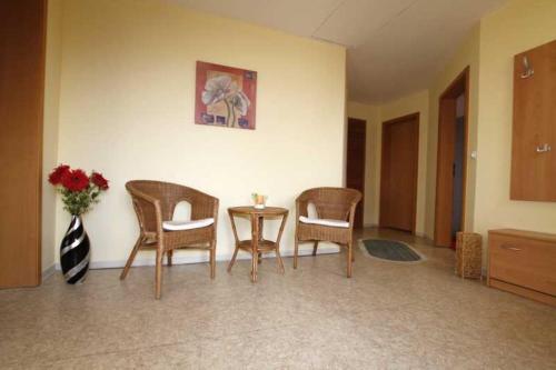a room with chairs and a table and a vase of flowers at Ferienwohnung Anna in Schwarz