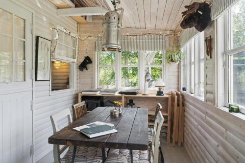 a dining room with a wooden table and chairs at Wooden House With Wild Garden By Sejerø Bay in Kalundborg