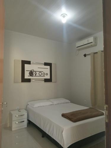 a bedroom with a bed and a picture on the wall at Aconchego do velho chico in Piranhas