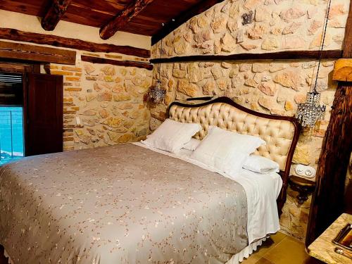 une chambre avec un lit dans un mur de pierre dans l'établissement BocallenaRural LASTRAS DE CUELLAR, à Lastras de Cuéllar