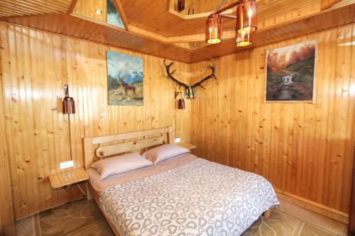 a bedroom with a bed in a wooden wall at Будиночок для щастя in Yaremche