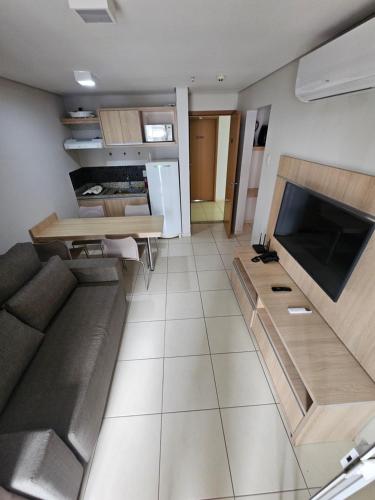 a kitchen and living room with a couch and a table at Apartamento 704-C Casa da Madeira Caldas Novas in Caldas Novas