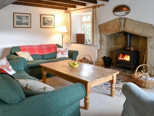 a living room with two couches and a fireplace at East House Farm in Beckermonds