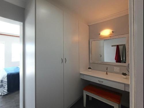 a bathroom with a sink and a mirror at Ships Bell at Port St Francis in St Francis Bay